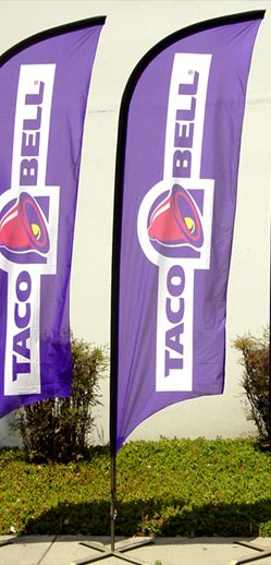 Pair of purple feather flags with a printed logo outside a business