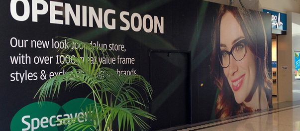 Branded hoarding wall screening a construction site from the sidewalk
