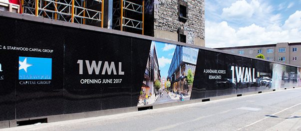 Large-format hoarding graphics advertising a new building project