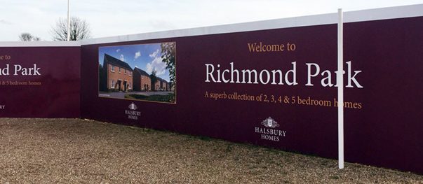 Printed construction hoarding panels along a development site fence