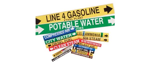 Pipe markers with flow arrows applied to industrial piping