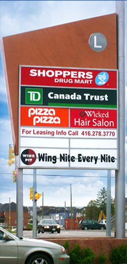 Double-sided pylon sign with tenant panels at a commercial plaza