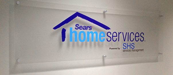 Acrylic lobby sign mounted behind a reception desk